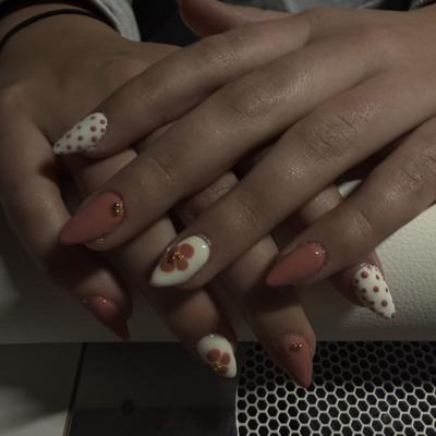 Pink almond nails with white polka dots and floral accent nails